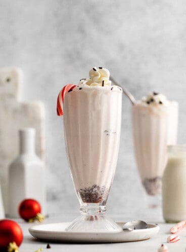 A tall milkshake glass filled with peppermint milkshake.