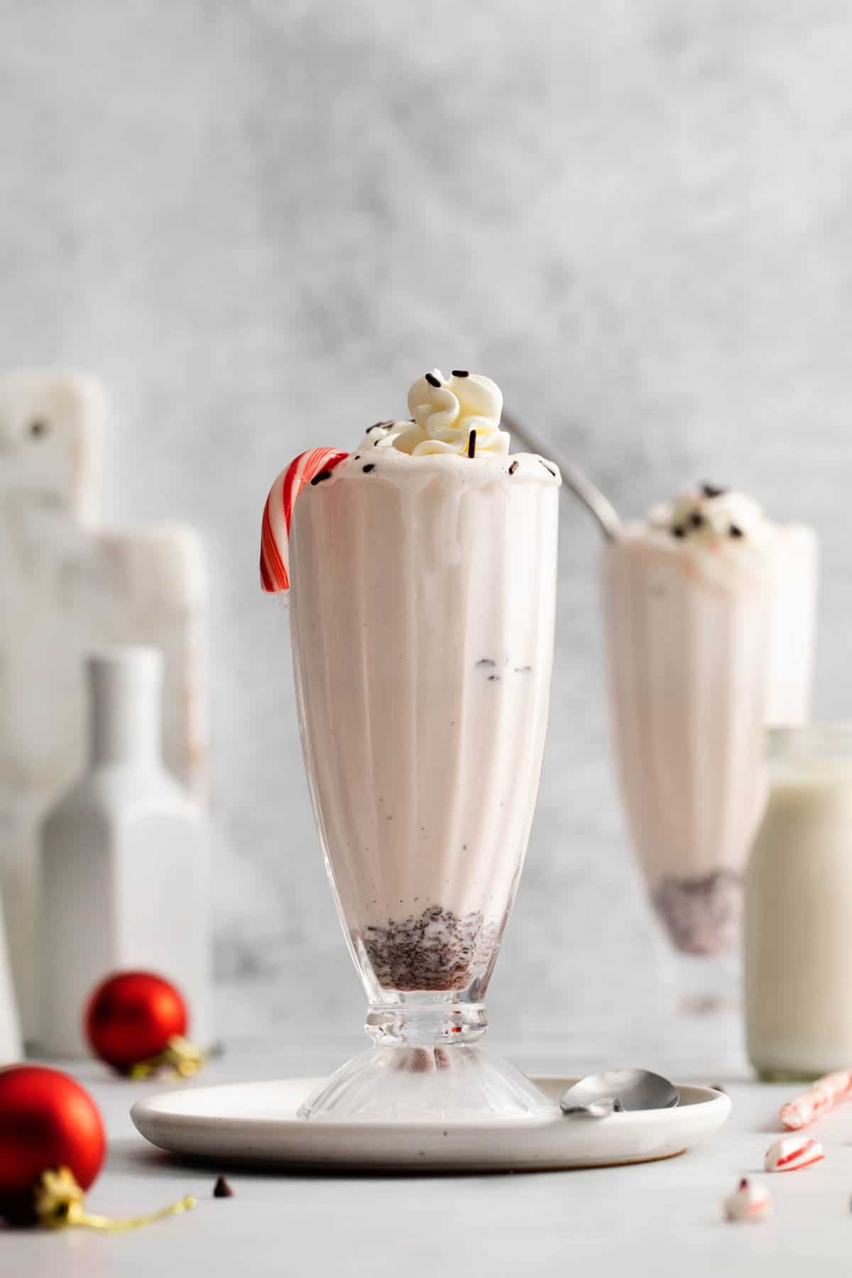 A tall milkshake glass filled with peppermint milkshake.