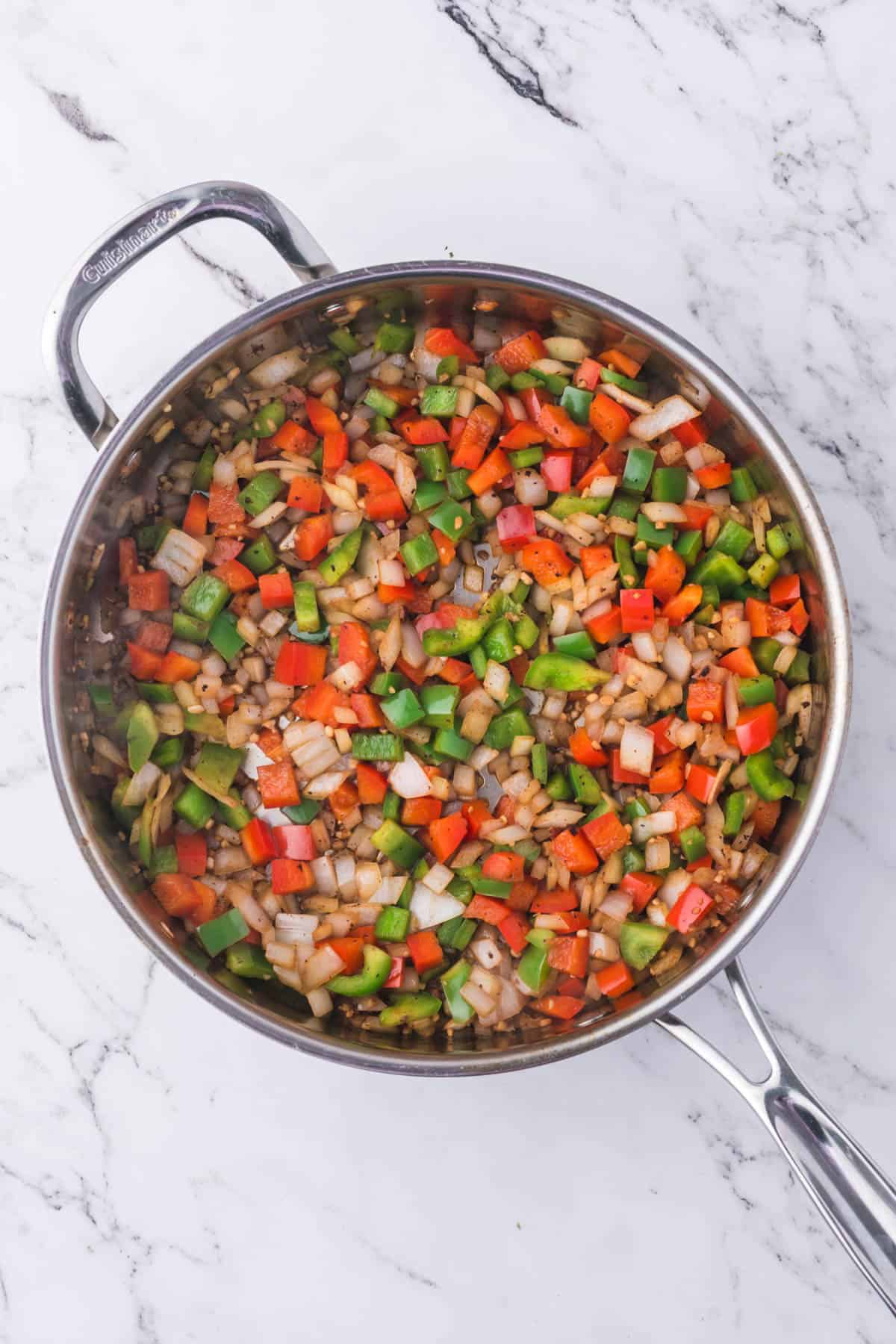 Sauteeing diced vegetables in a pan.