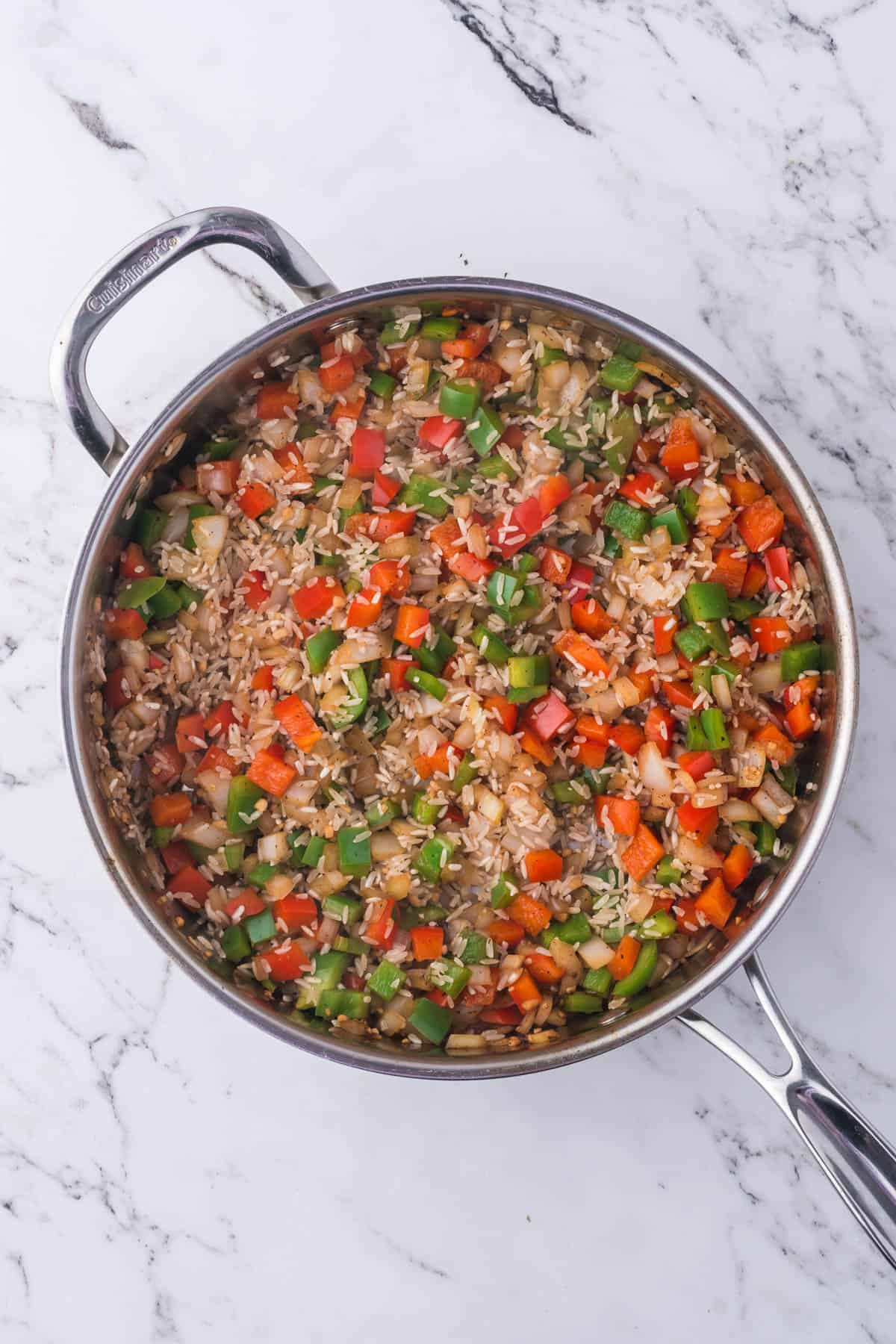 Adding rice to veggies in a pan.