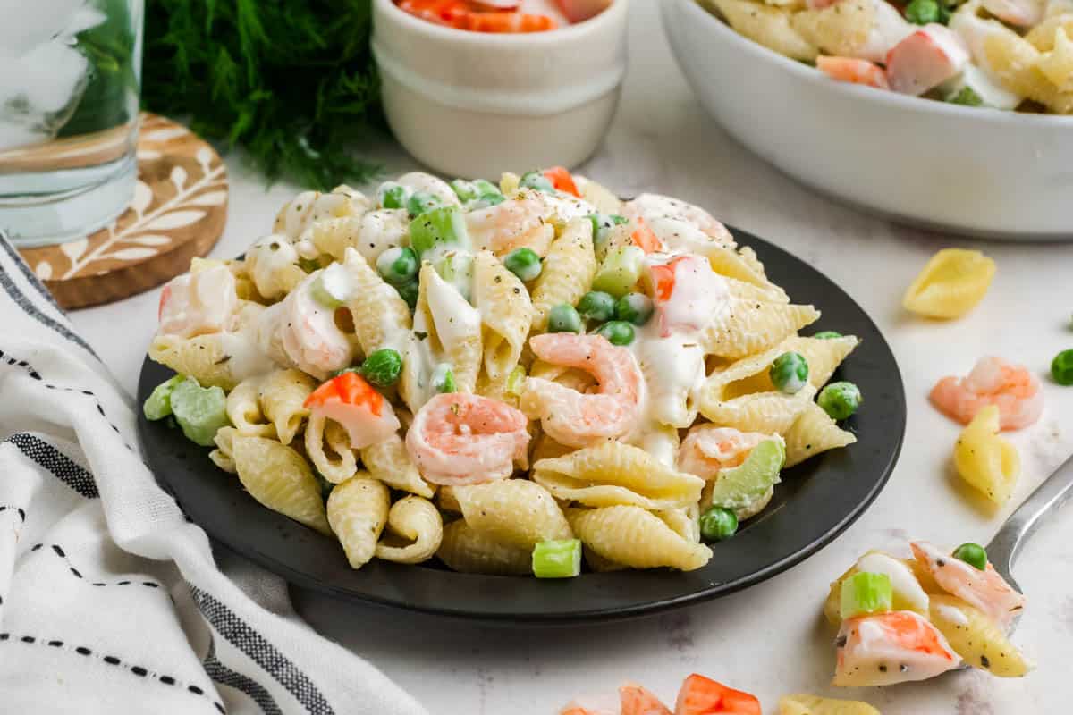Seafood pasta salad on a black plate.