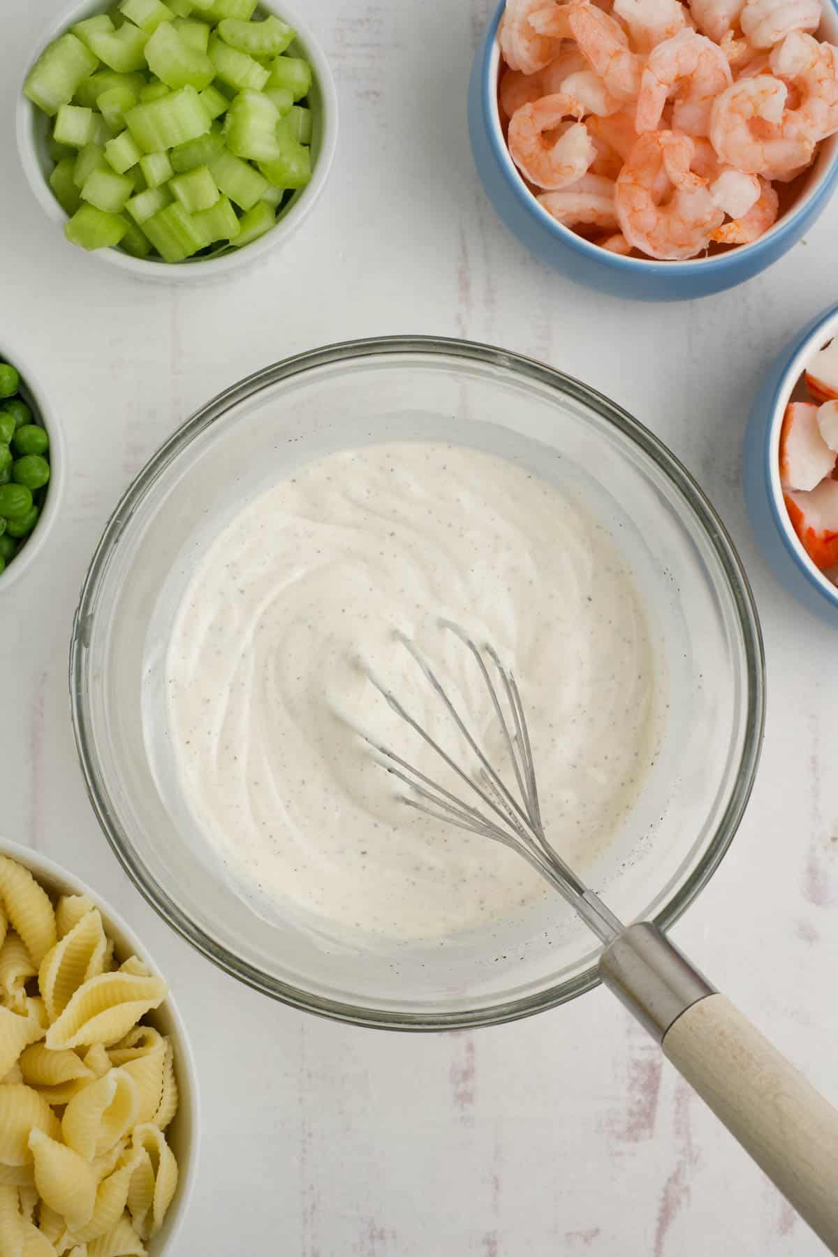 Whisked dressing in a bowl for seafood pasta salad.