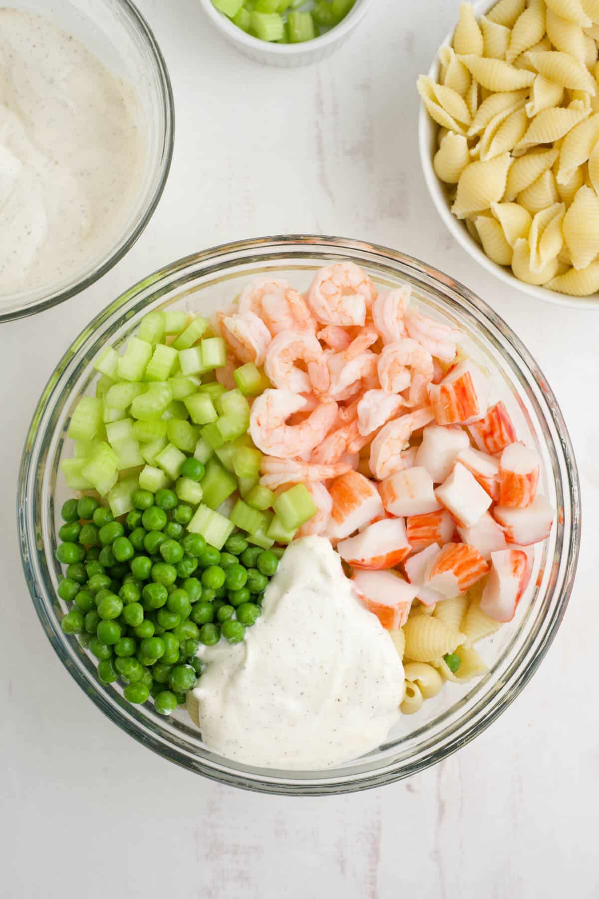 Seafood pasta salad ingredients in a large mixing bowl.