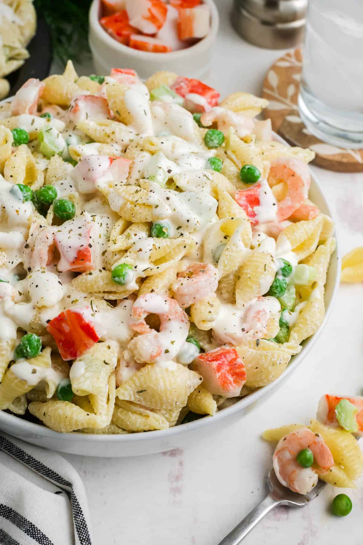 A close up image of seafood pasta salad in a large serving bowl.