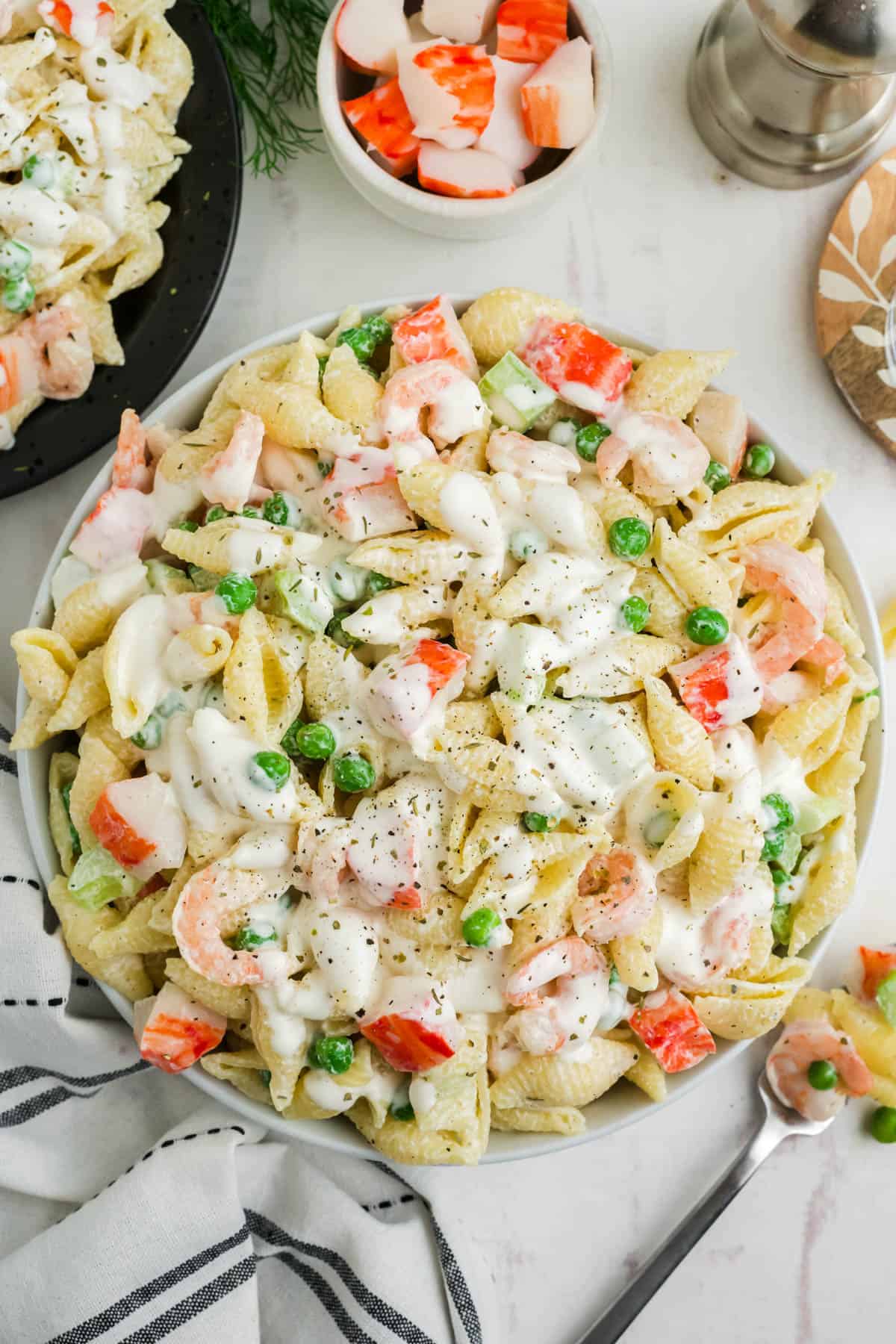 An overhead image of pasta salad with shells and seafood.