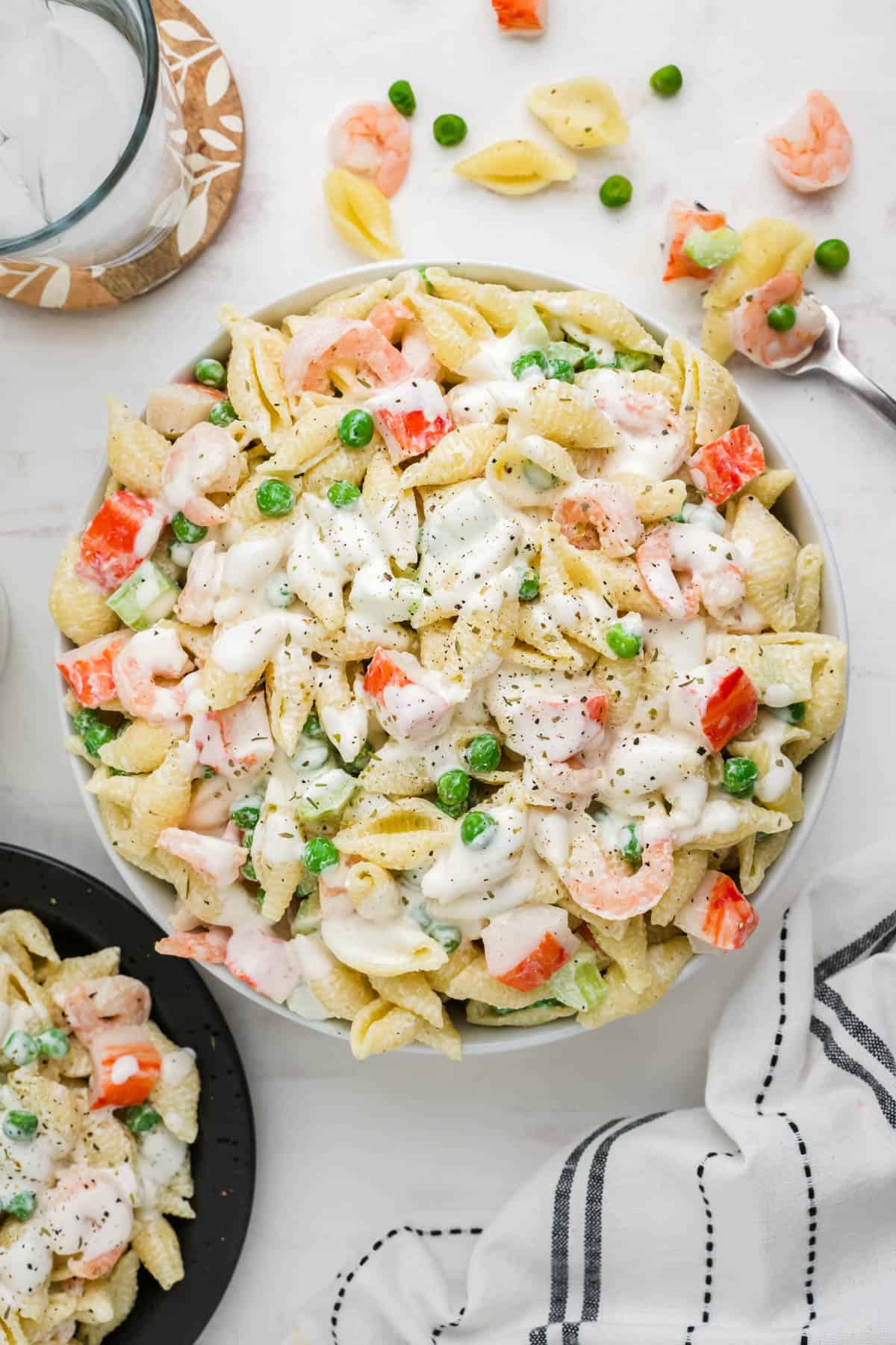An overhead image of a large serving bowl of seafood pasta salad.