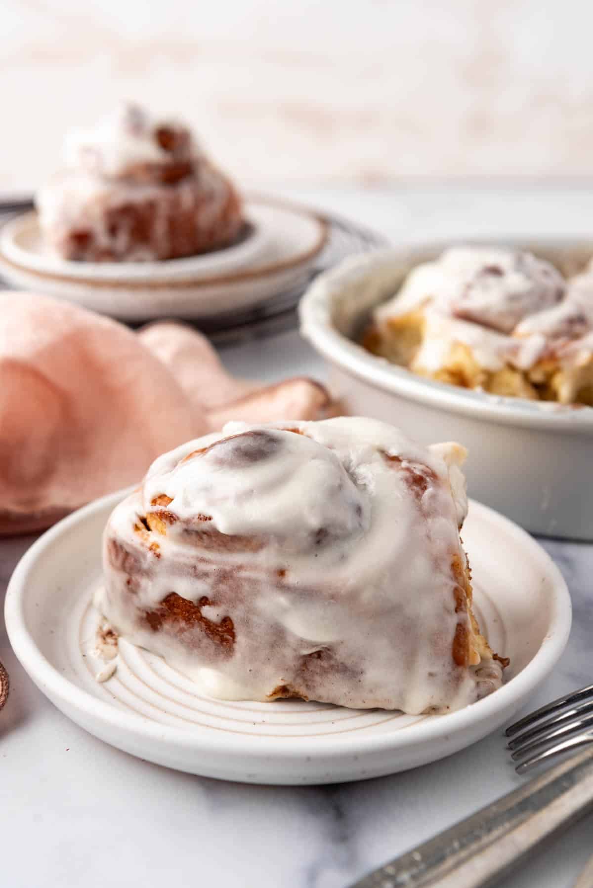 A soft and gooey cinnamon roll on a plate.