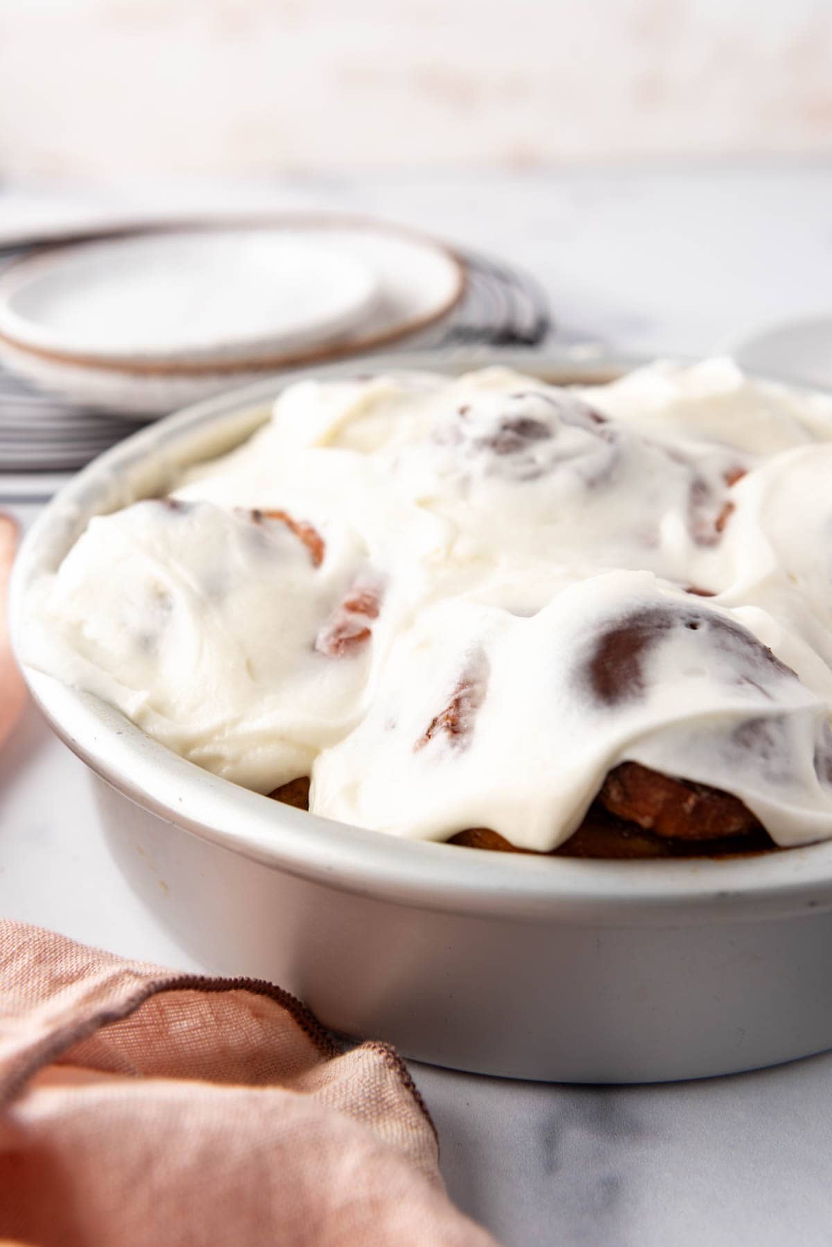 An image of frosted cinnamon rolls in a pan.