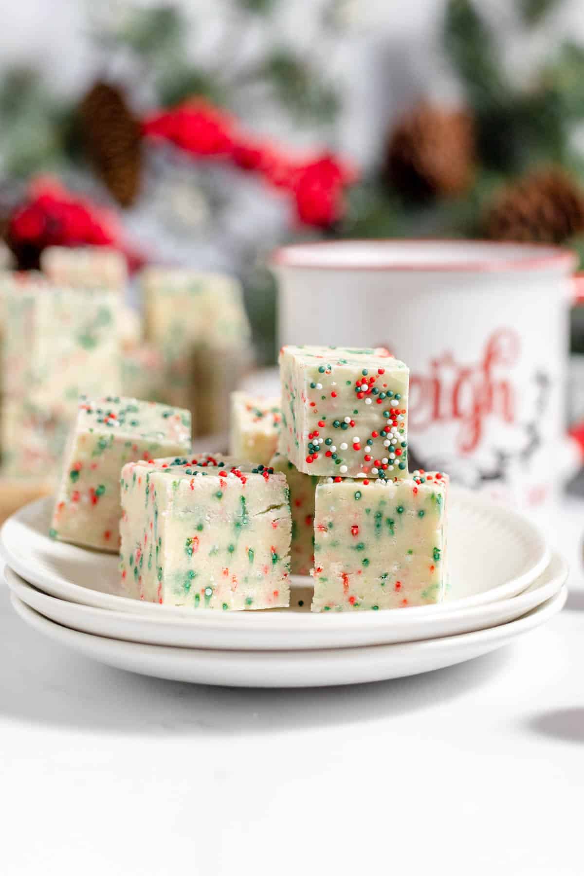 Stacked pieces of sugar cookie fudge on a plate.