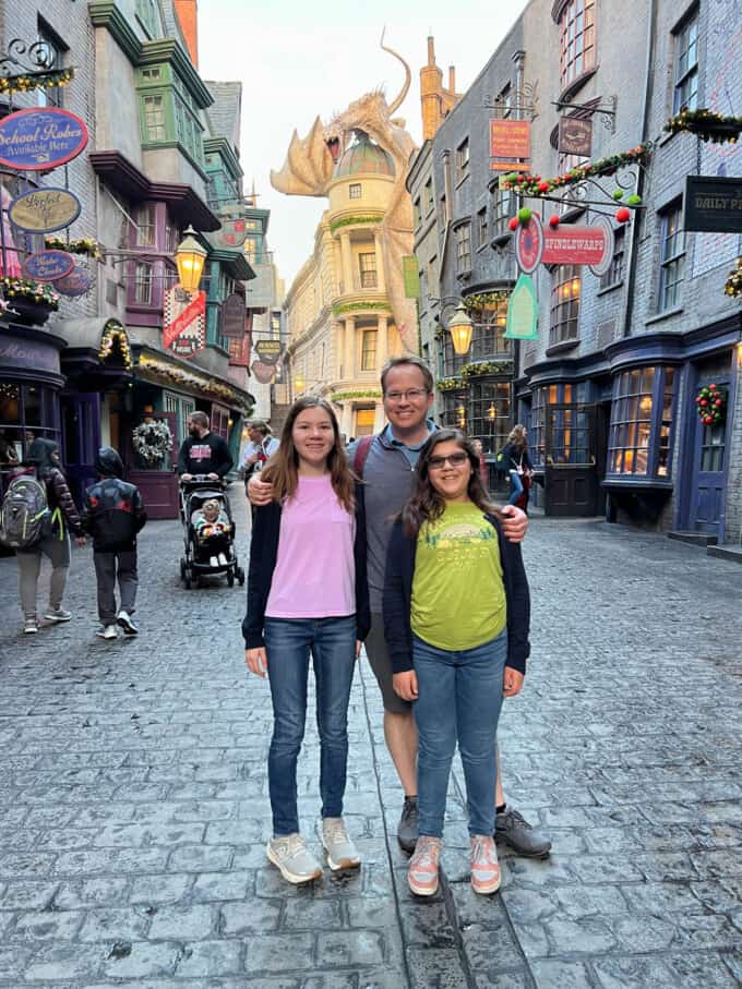 A dad and two kids in Diagon Alley at the Wizarding World of Harry Potter.