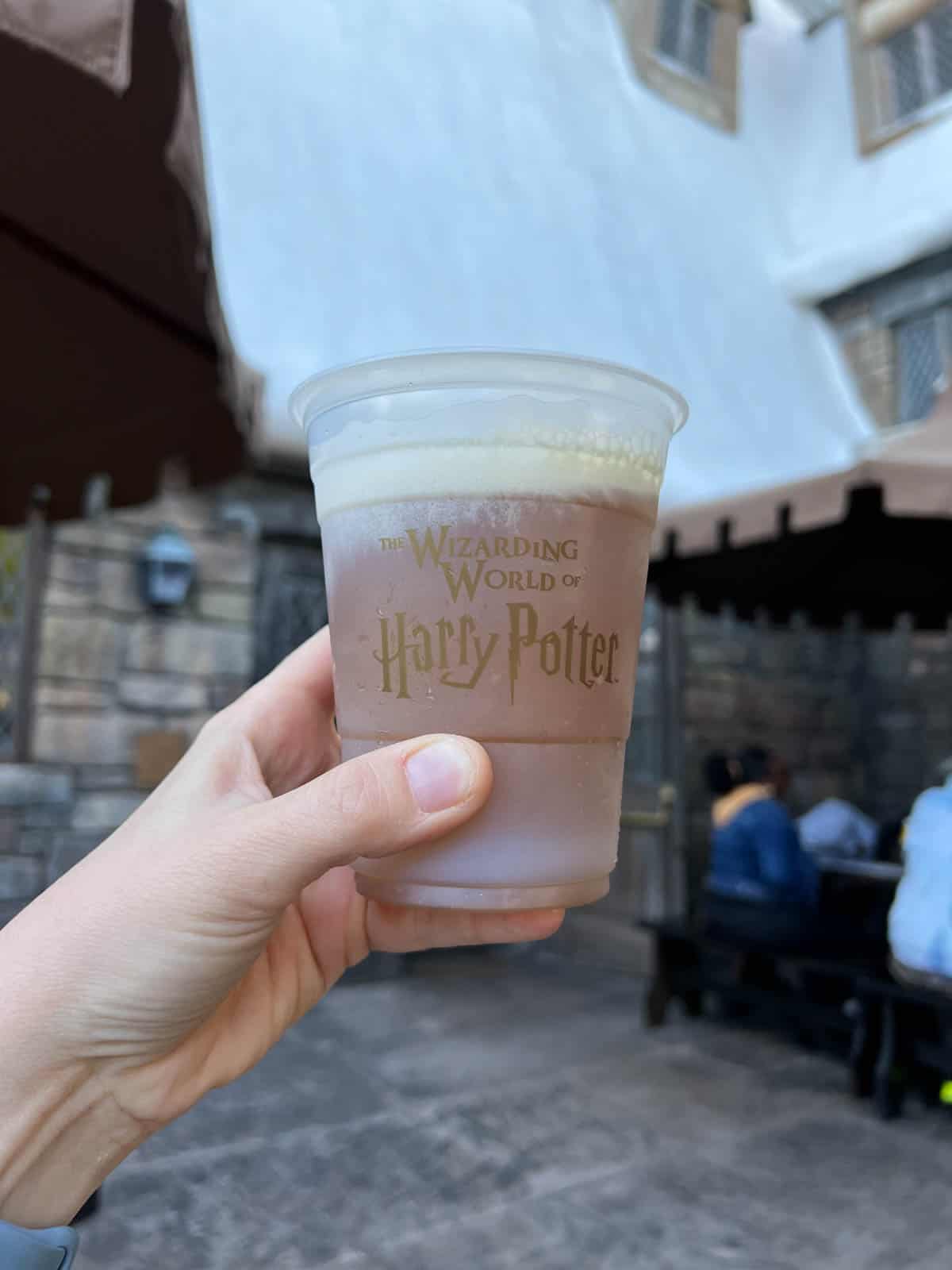 An image of a hand holding a frozen butterbeer.