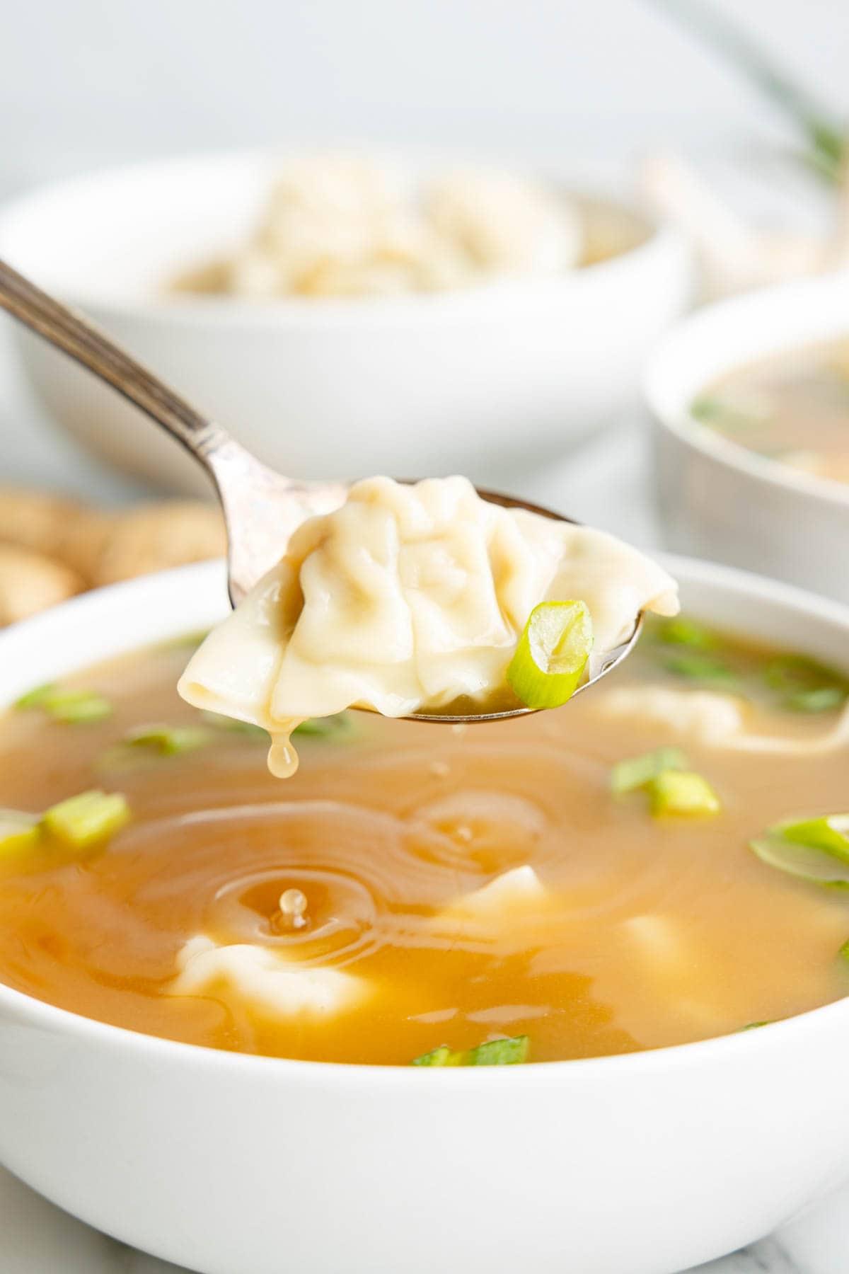 Close up of Wonton Soup in a white bowl.