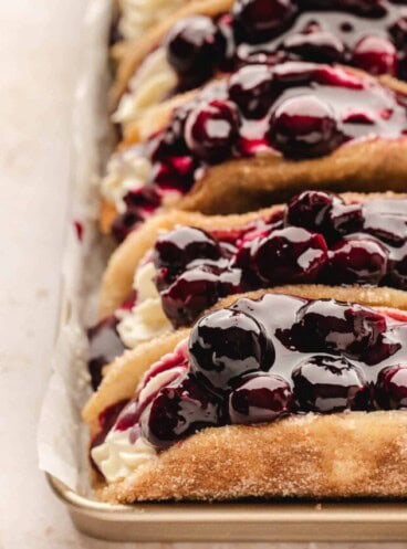 A close image of blueberry cheesecake pie filling on blueberry cheesecake tacos.