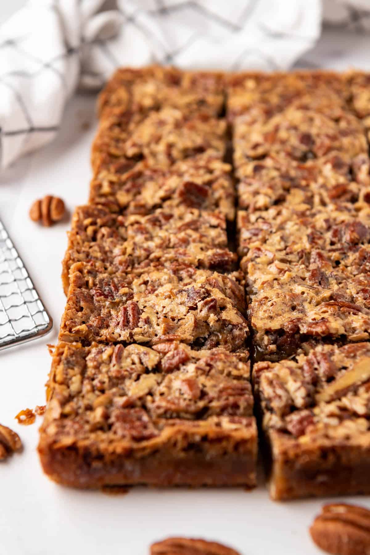 Sliced pecan pie bars on a white surface.