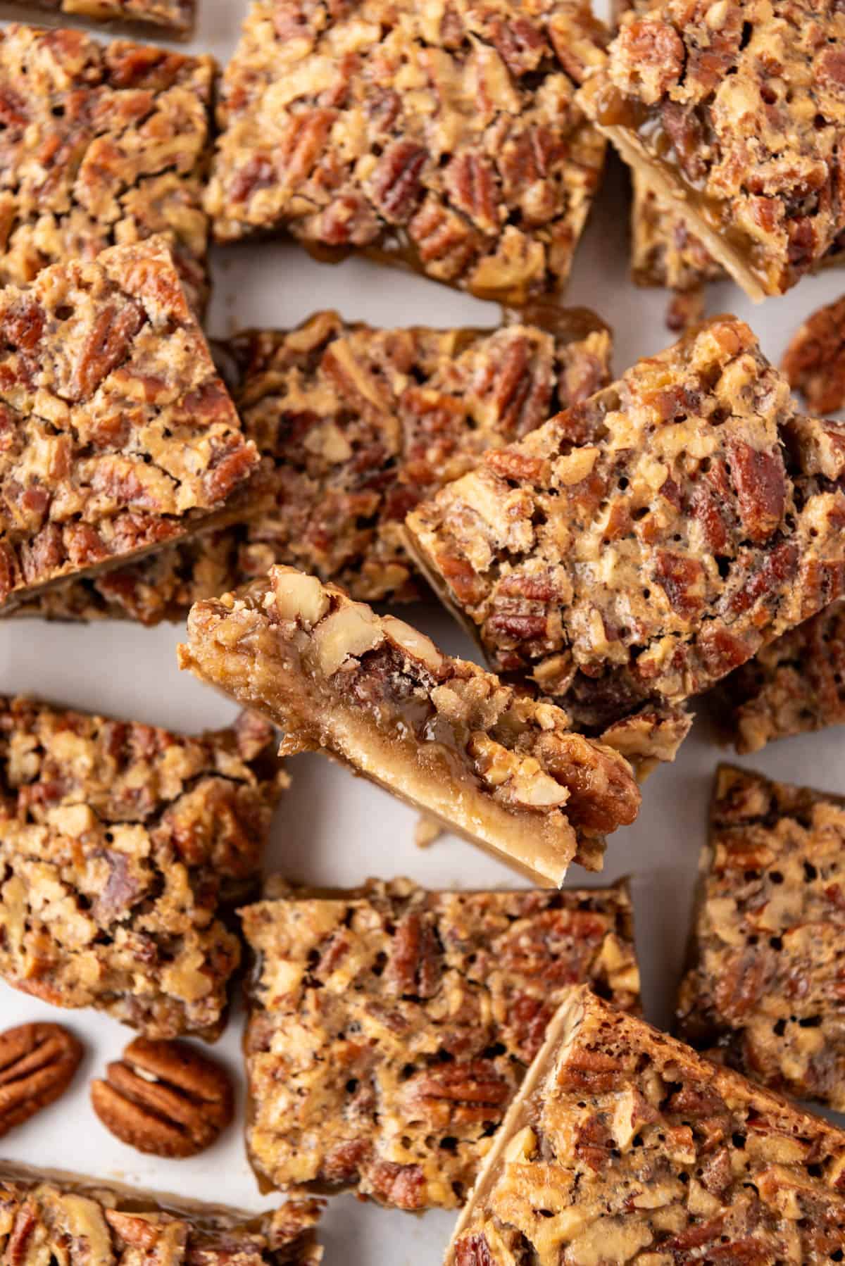 An overhead image of pecan pie bars cut into squares and scattered about haphazardly.