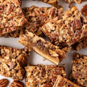 An overhead image of pecan pie bars cut into squares and scattered about haphazardly.