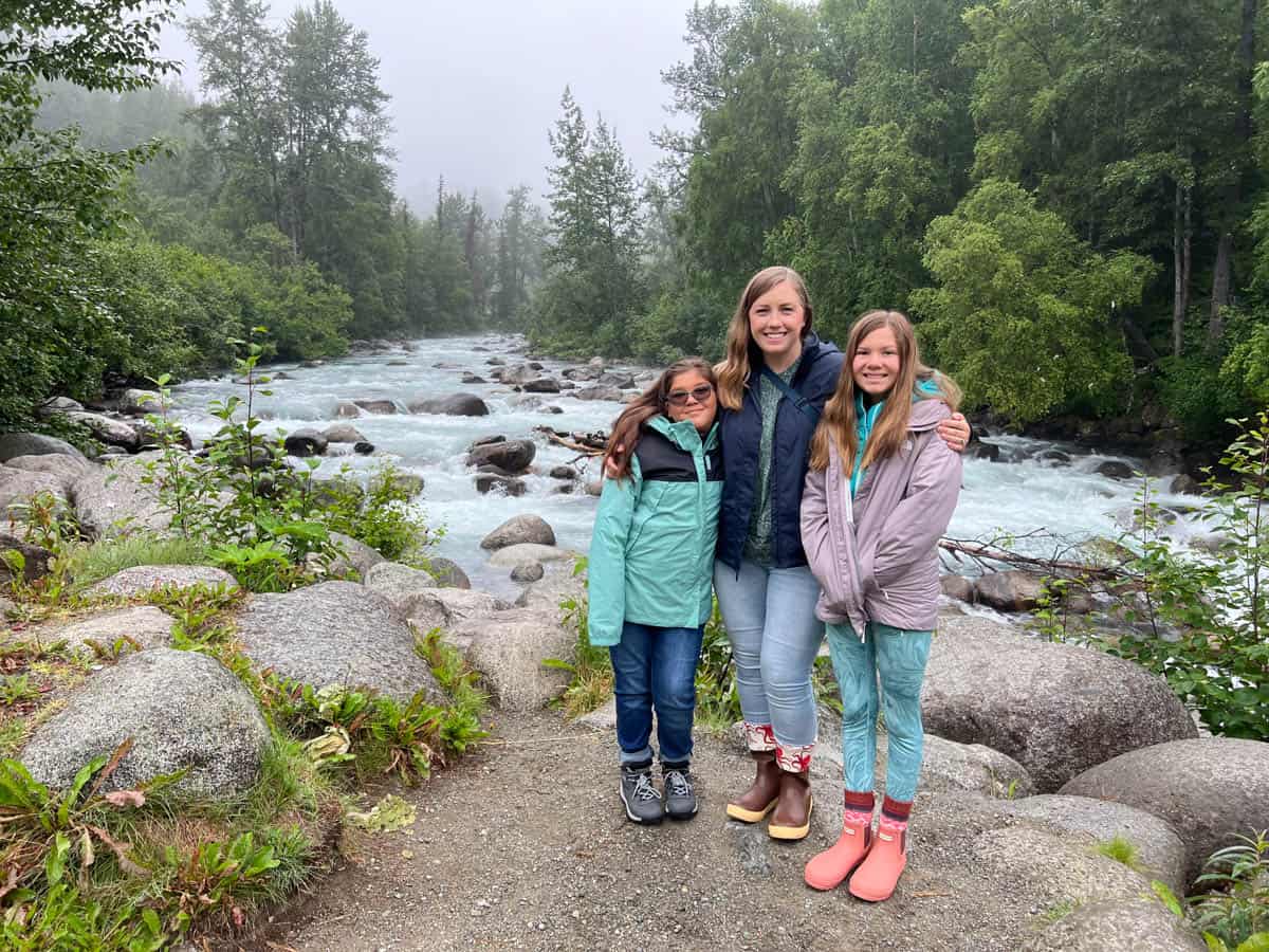 A mom and two kids in front of a river near Hatcher pass in Alaska.