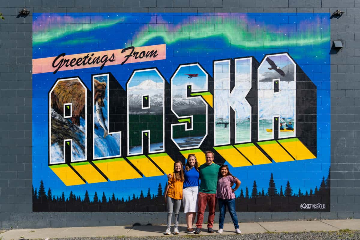 A family in front of the Alaska sign in Anchorage.