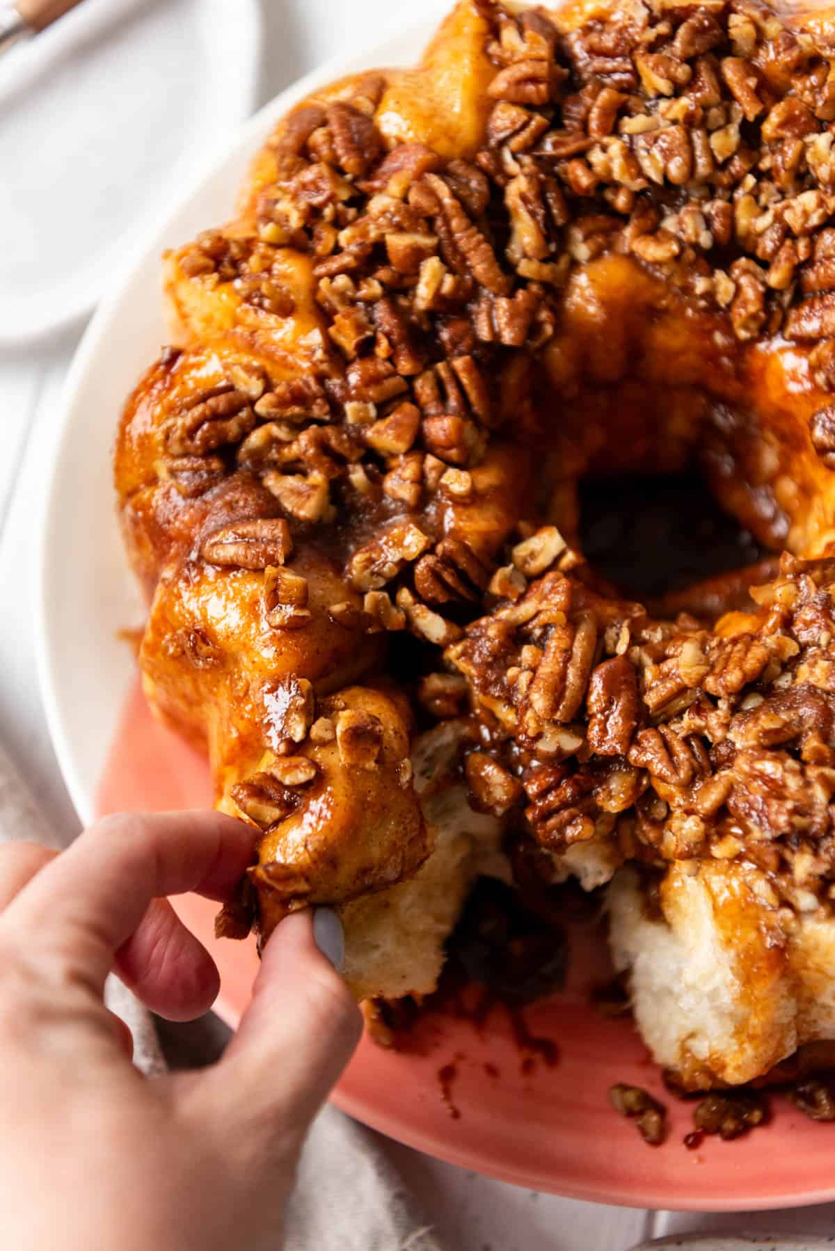 An image of fingers pinching off a piece of monkey bread.