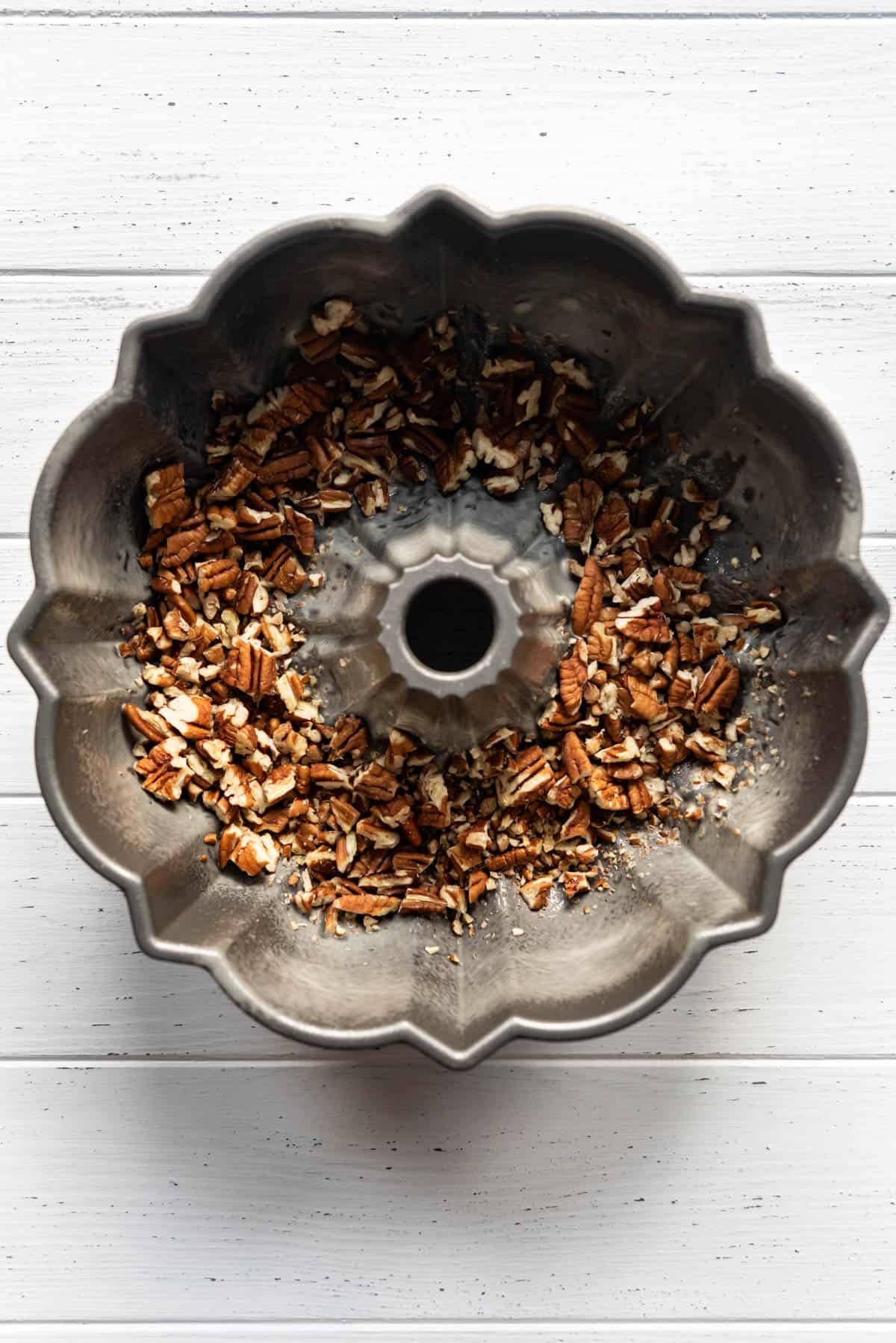 Chopped pecans in a bundt pan.