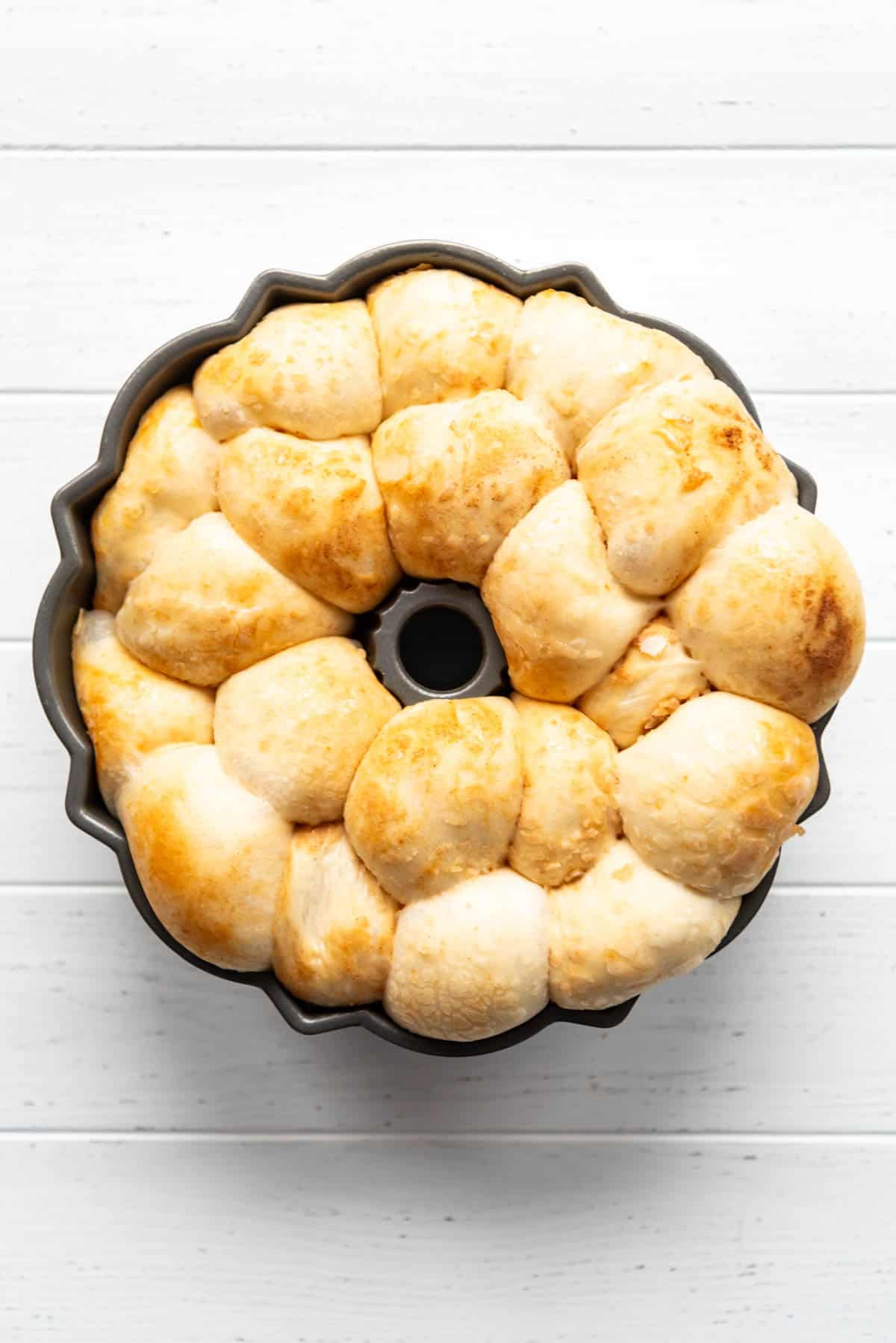 Puffy risen monkey bread in a bundt pan.