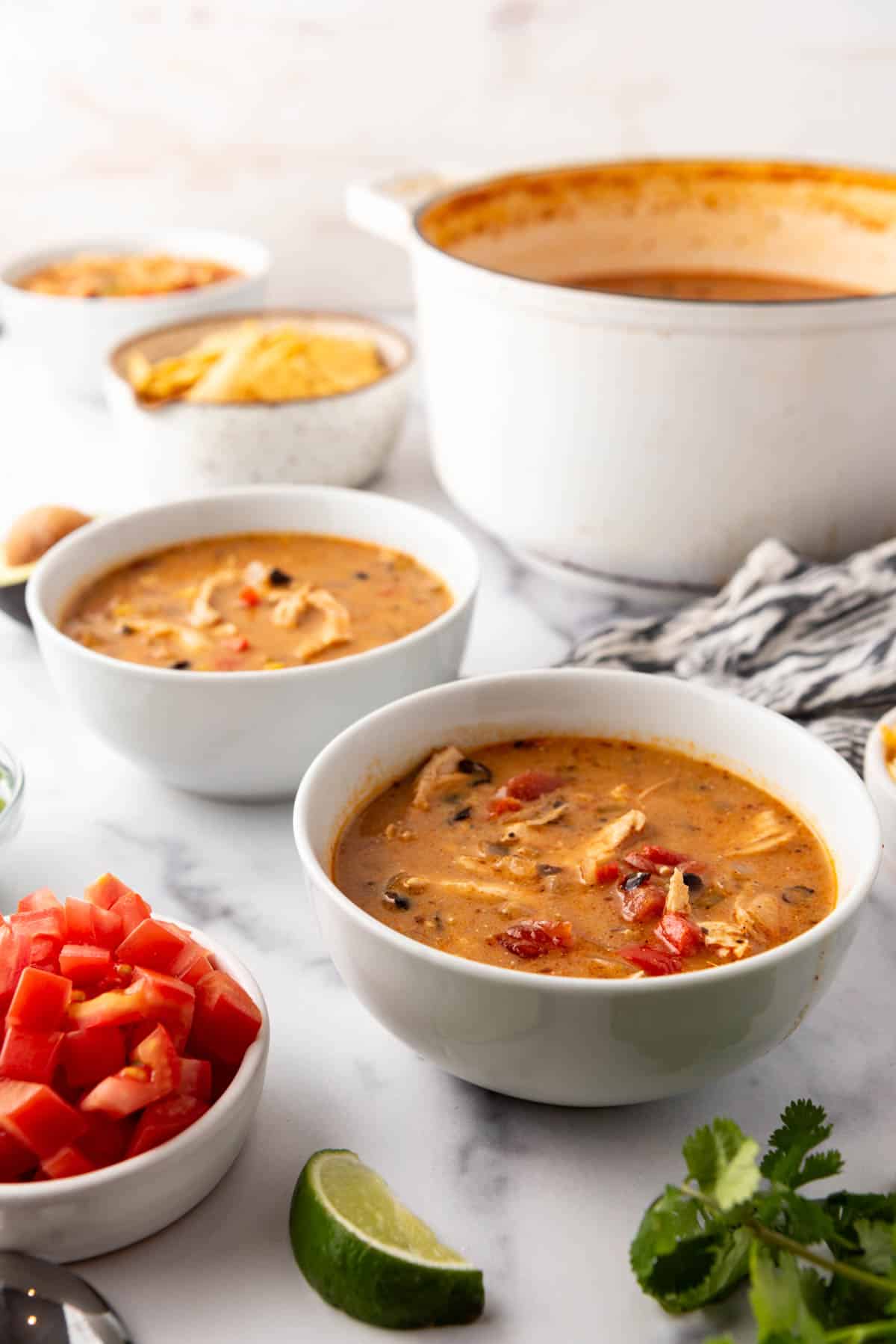 Bowls of chicken tortilla soup before adding toppings to each of them.