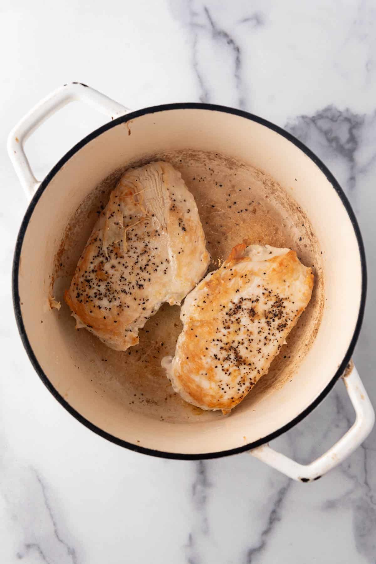 Seared chicken breasts in a dutch oven.