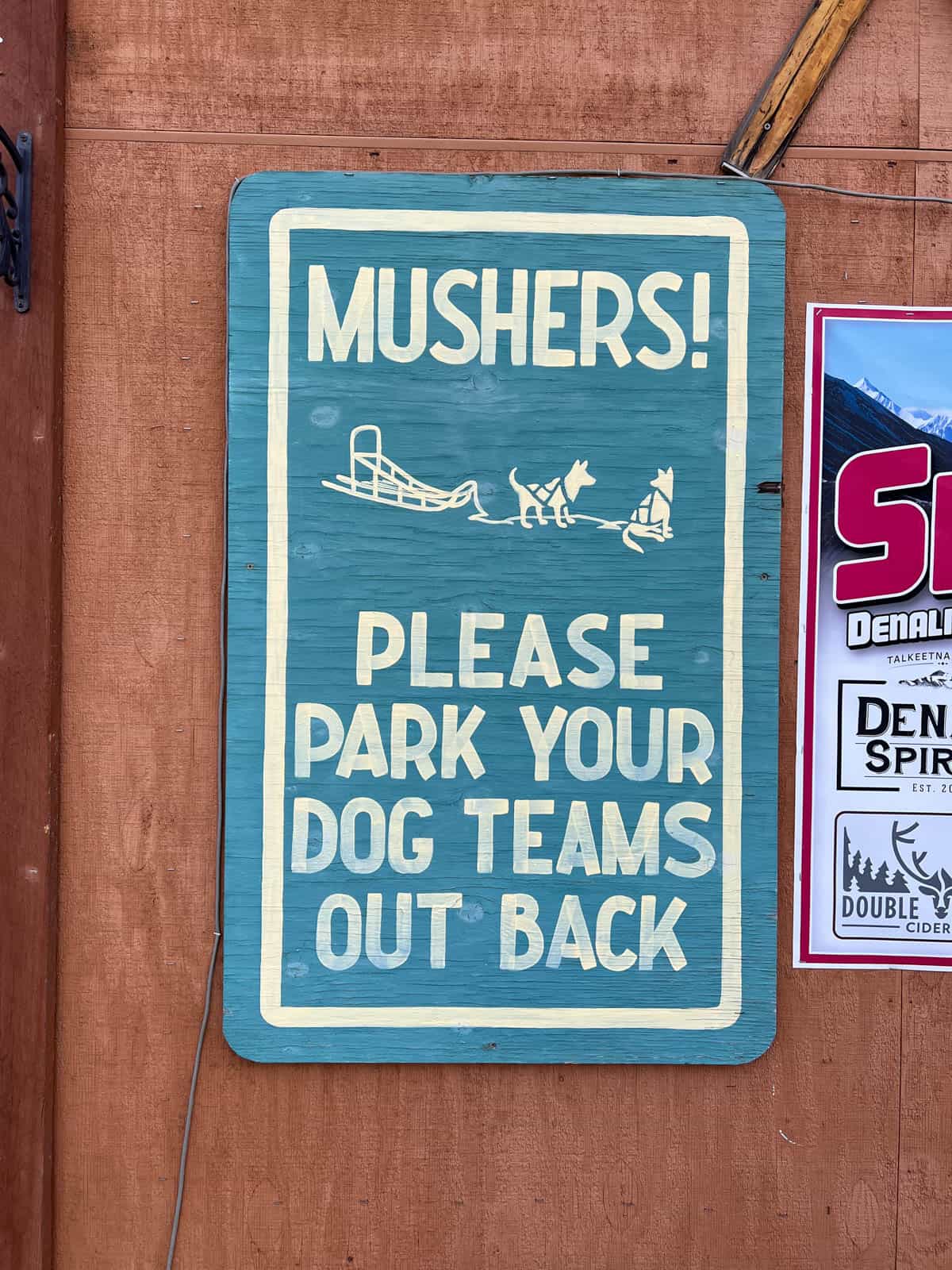An image of a sign telling sled dog owners to park dog teams out back.