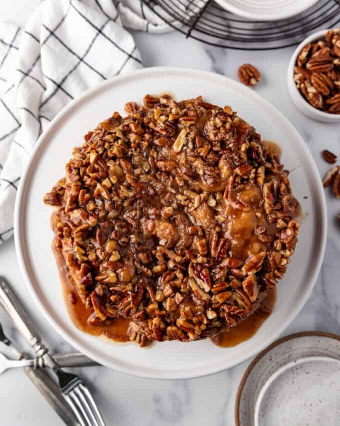An overhead image of a small batch of six sticky buns covered in caramel and pecans.