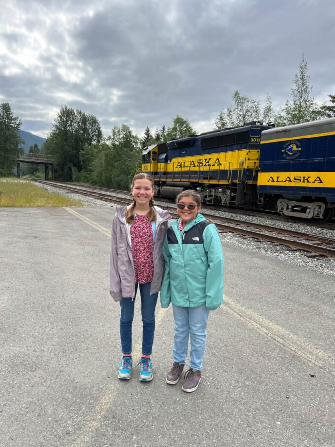 Two kids in front of an Alaska Railway train.