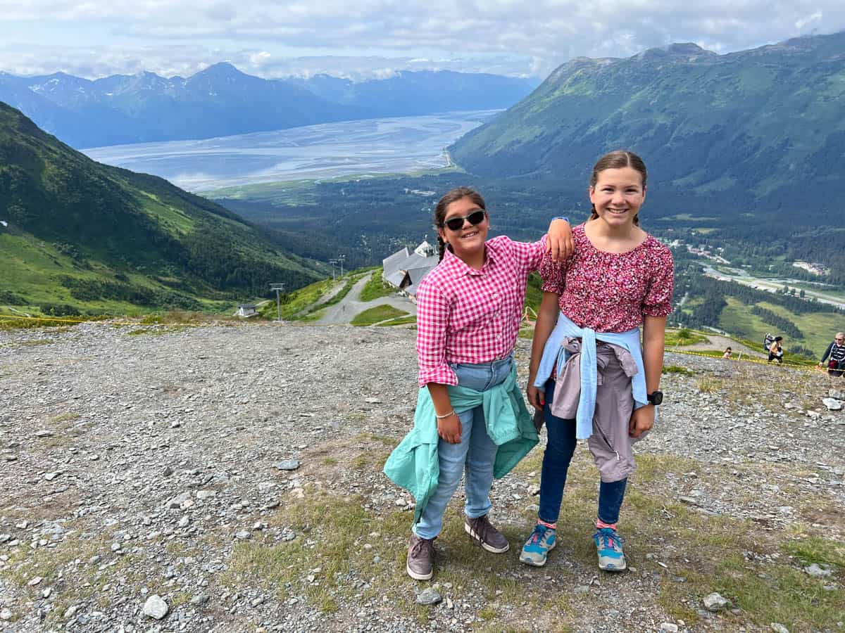 Two girls at the top of a mountain peak in Girdwood, Alaska.
