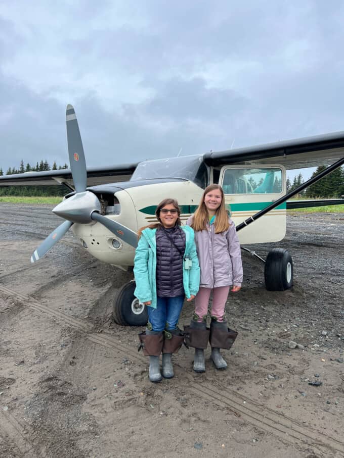 Two children in front of a bush plane in Alaska.