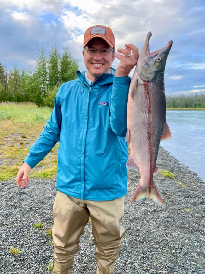 A man holding up a sockeye salmon in Alaska.