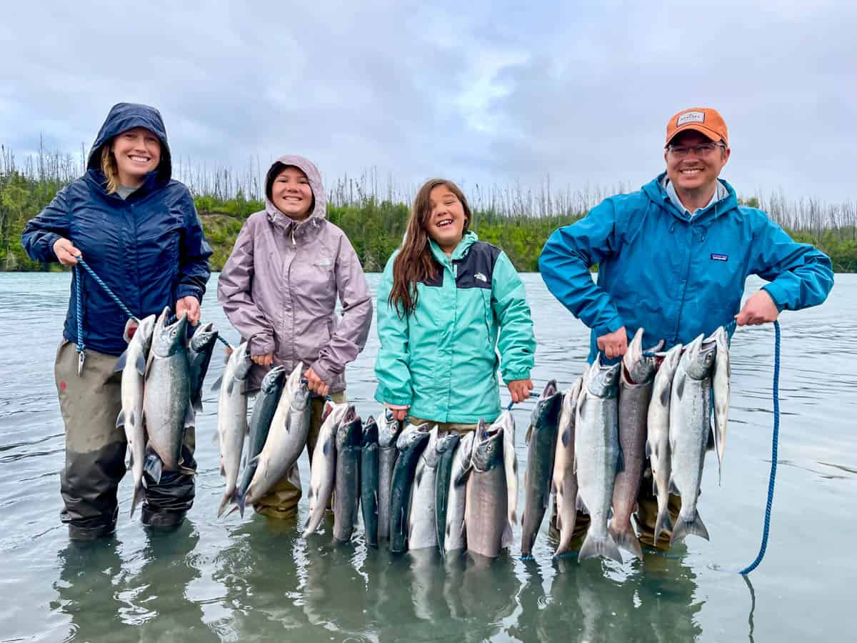 An image of a family holding a string of sockeye salmon in Alaska.