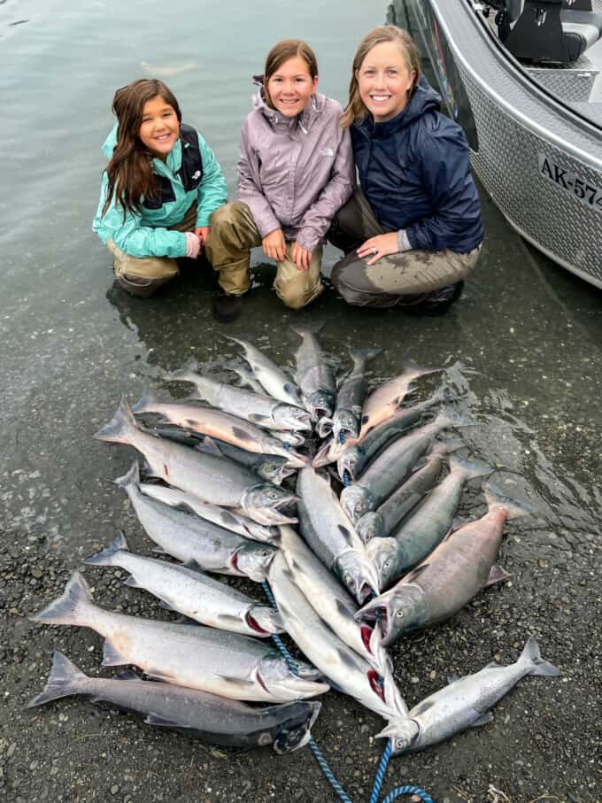 A mom and two daughters beside a stringer of sockeye salmon in Soldotna, Alaska.