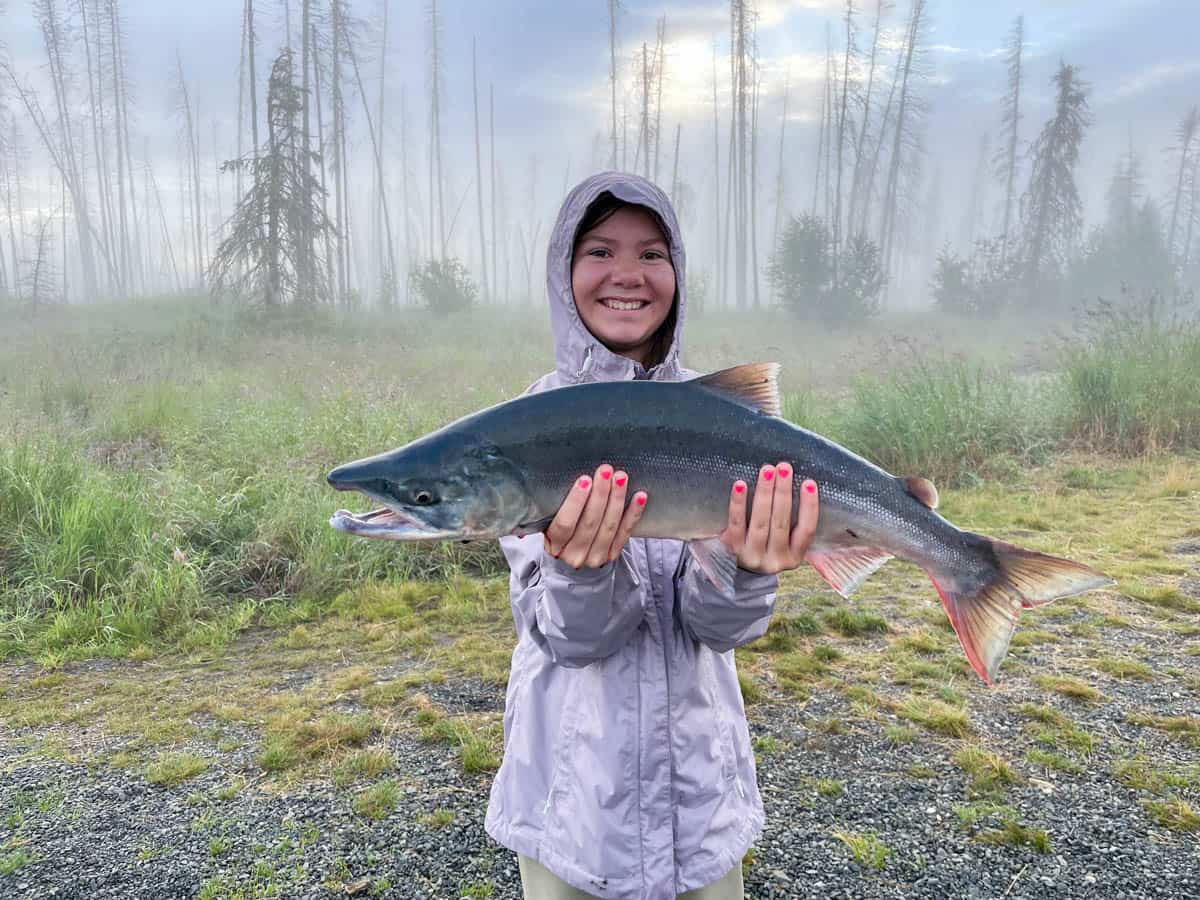 A girl holding a sockeye salmon that she caught in Soldotna, Alaska.