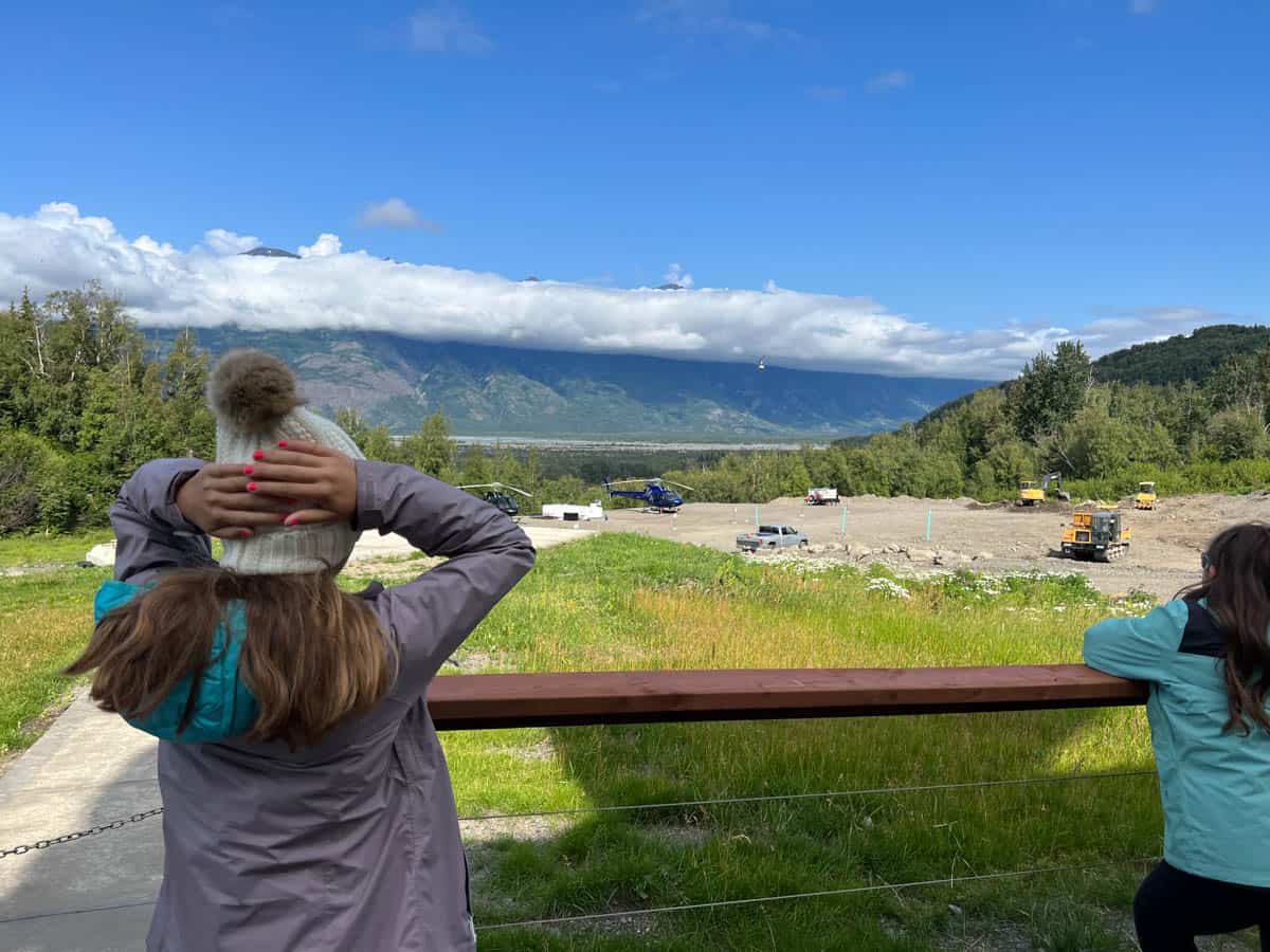 Kids watching helicopters land and take off in Alaska.