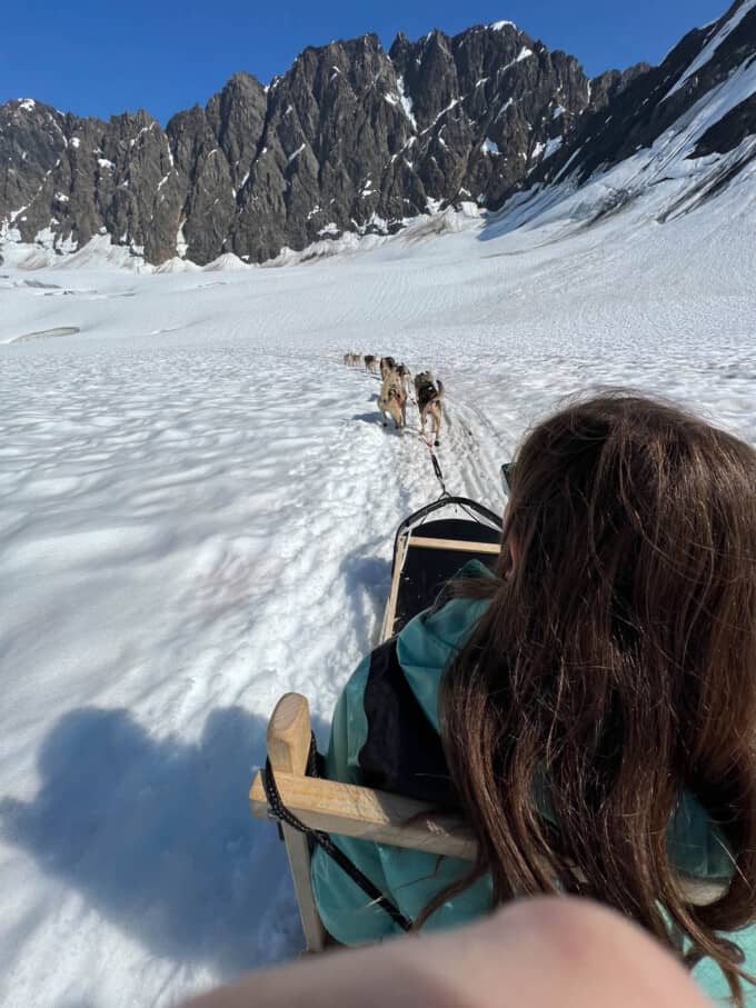 A dogsled team pulling a dogsled in the snow on the Knik Glacier.