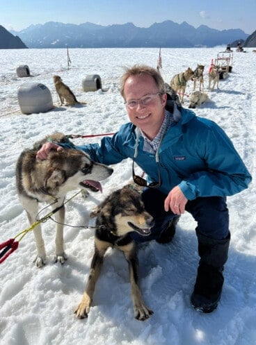 A man with sled dogs on the Knik Glacier in Alaska.