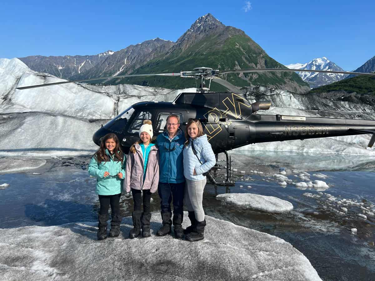 A family in front of a helicopter on the Knik Glacier in Alaska.