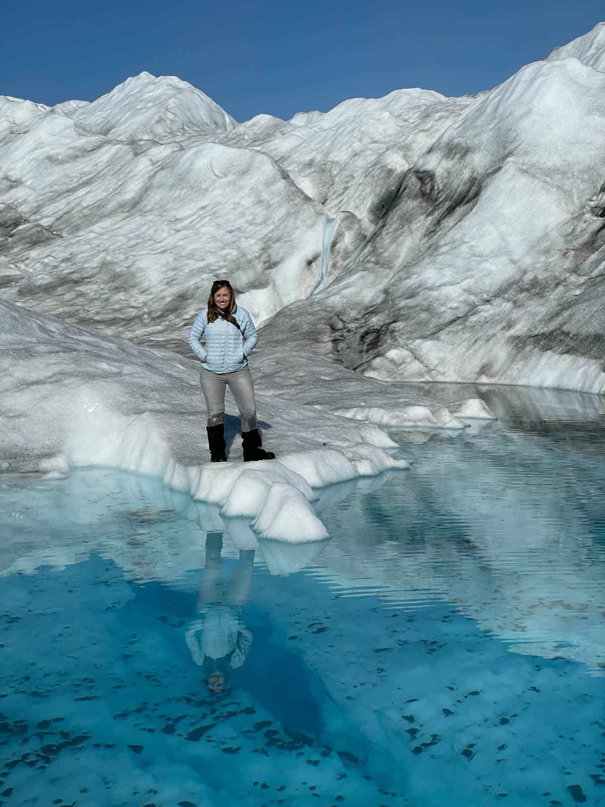 A woman on the edge of a glacial lake.