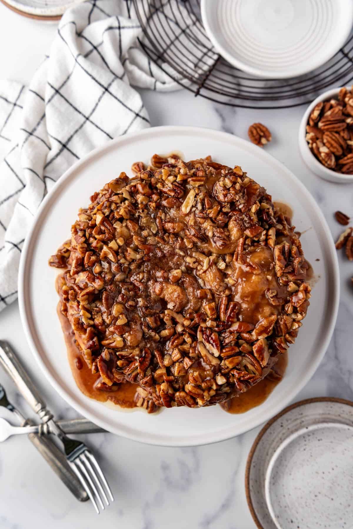 An overhead image of  a small batch of six sticky buns covered in caramel and pecans.