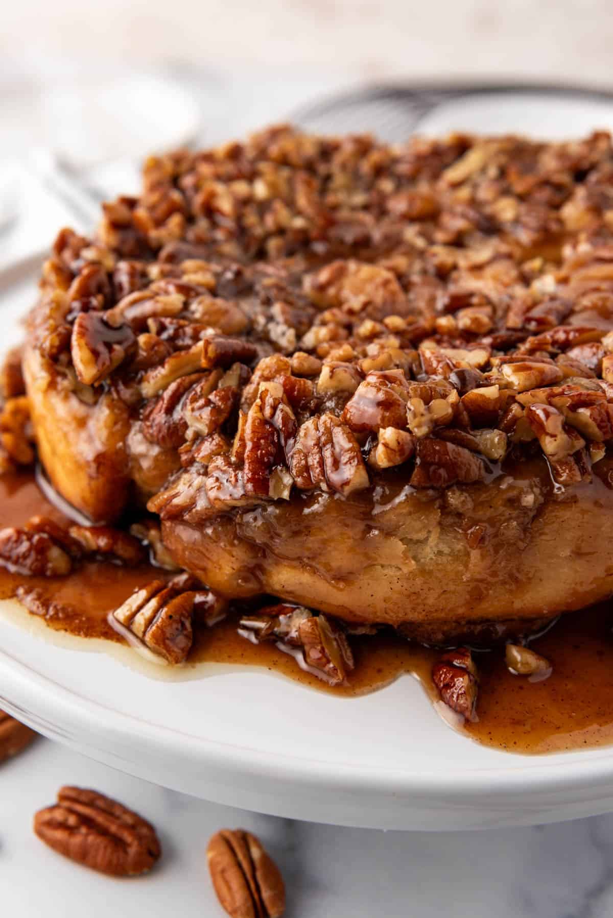 A close up image of sticky buns that have been turned out of their pan with the chopped pecans and caramel sauce on top.