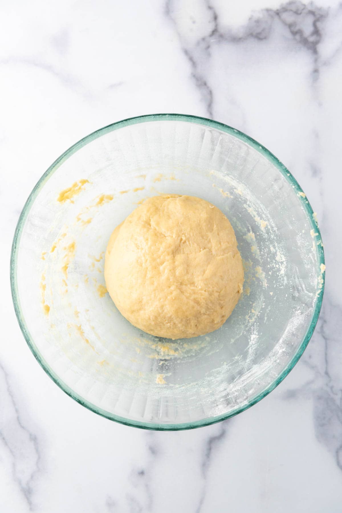Kneaded small batch cinnamon roll dough in a glass bowl.
