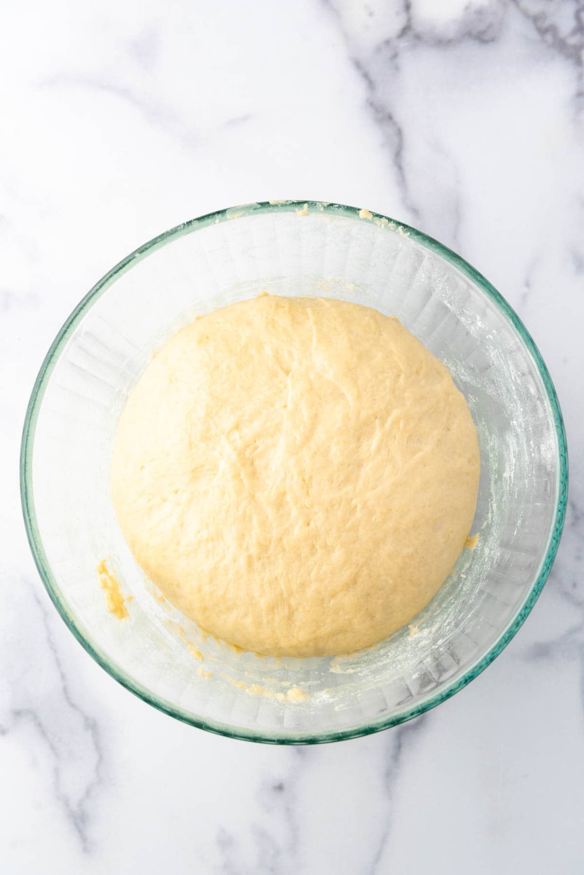 Cinnamon roll dough that has doubled in size in a bowl.