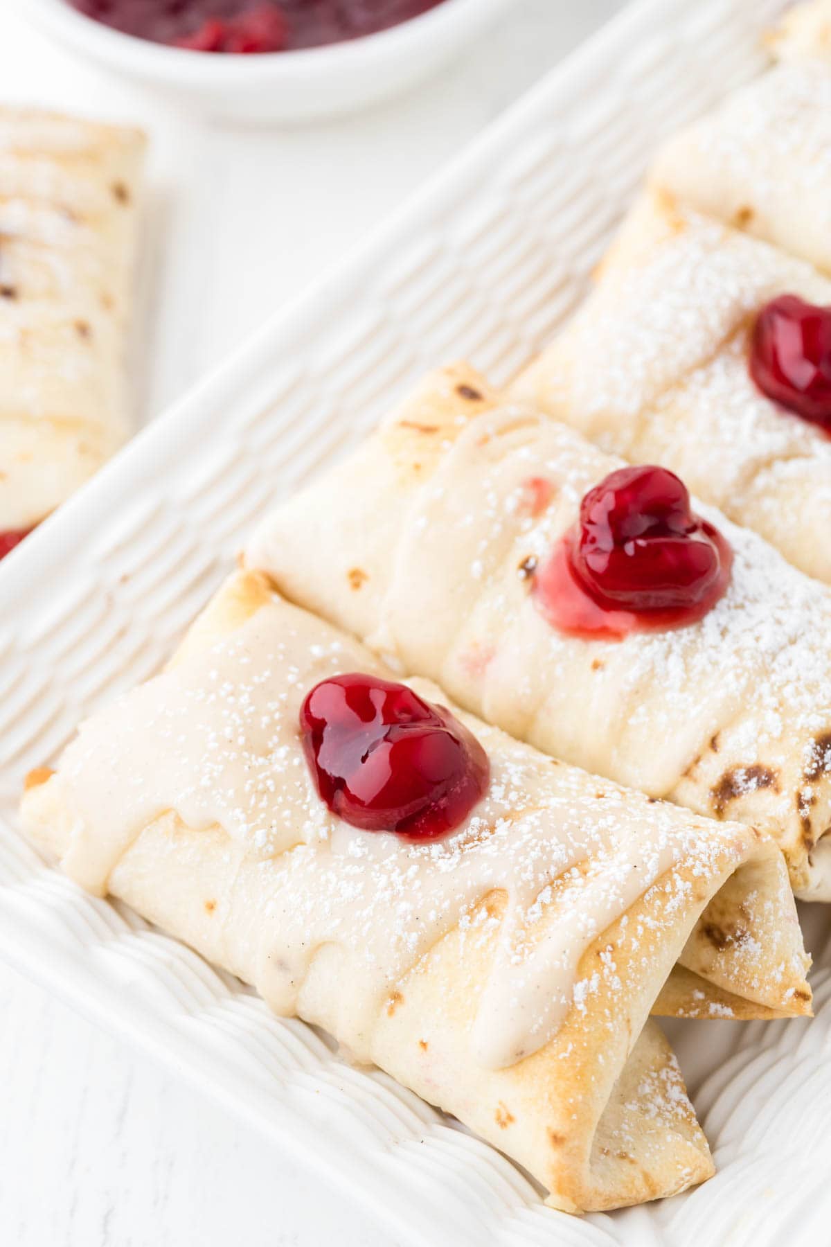 Cherry cheesecake chimichangas with cherry pie filling on top.
