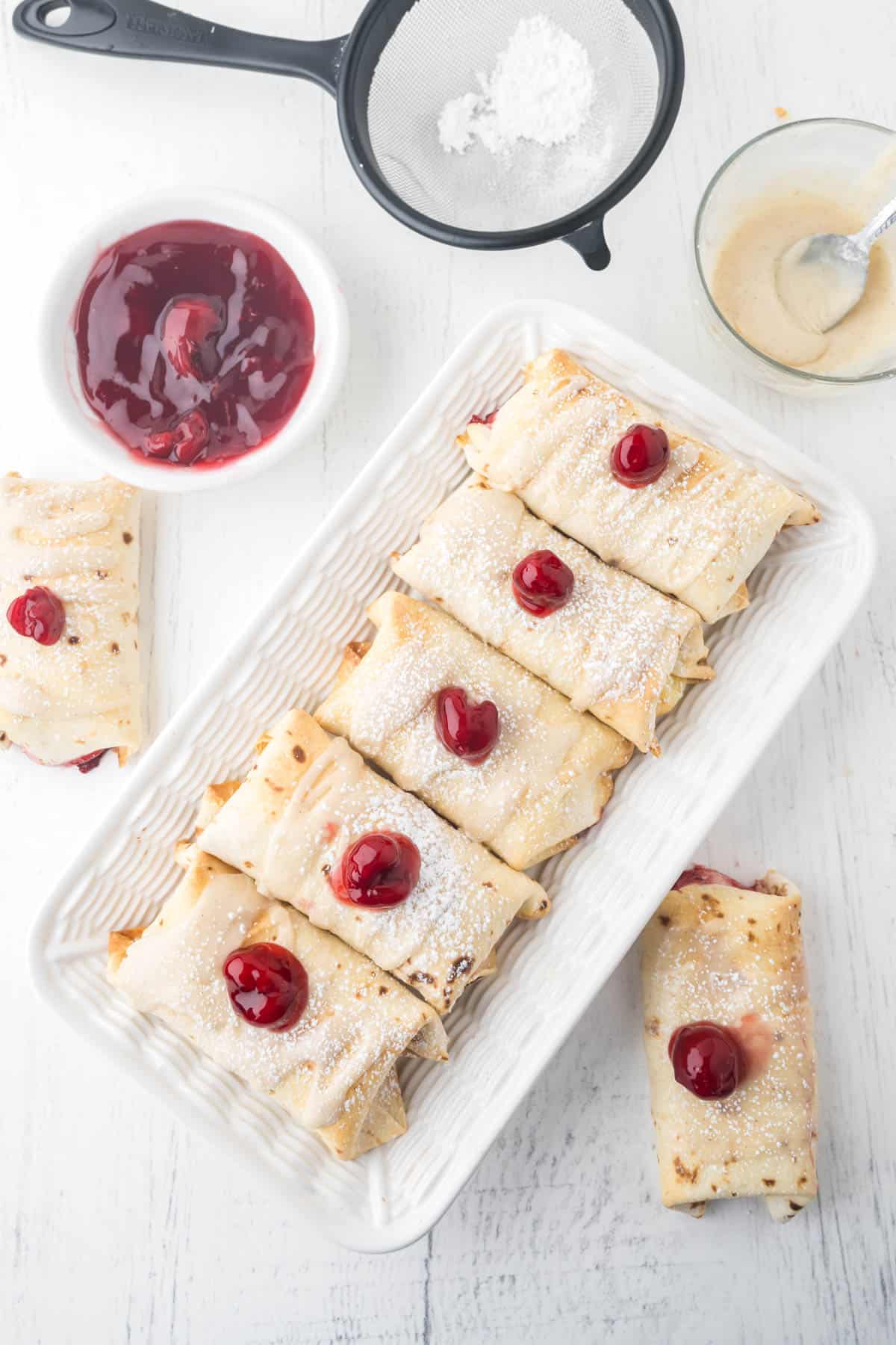 An overhead image of air fryer cherry cheesecake chimichangas on a serving plate.