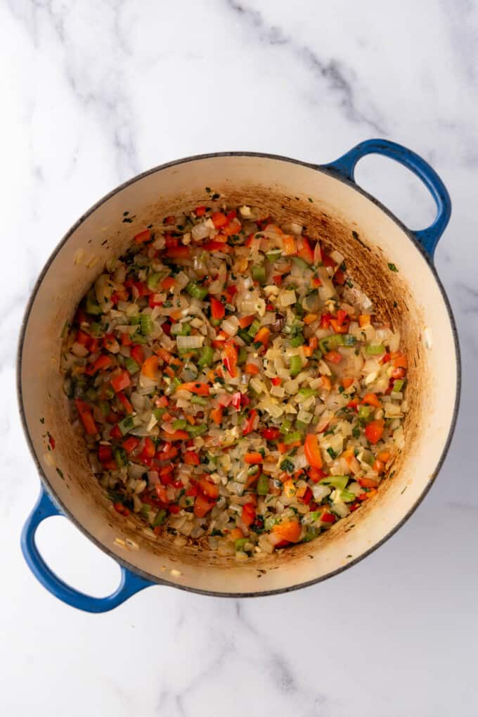 An image of sauteed veggies in a large dutch oven.