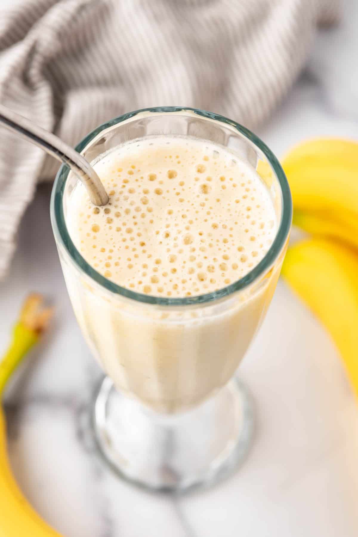 An image of banana smoothie in a milkshake glass.