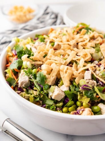 An image of a large white serving bowl of Thai chicken salad.